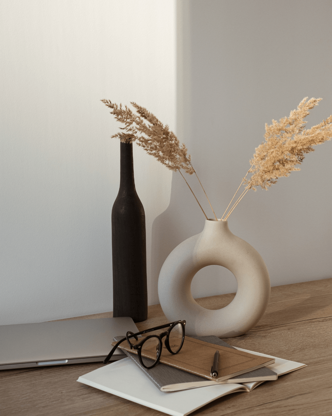 A collection of vases and glasses arranged on a table in an indoor setting