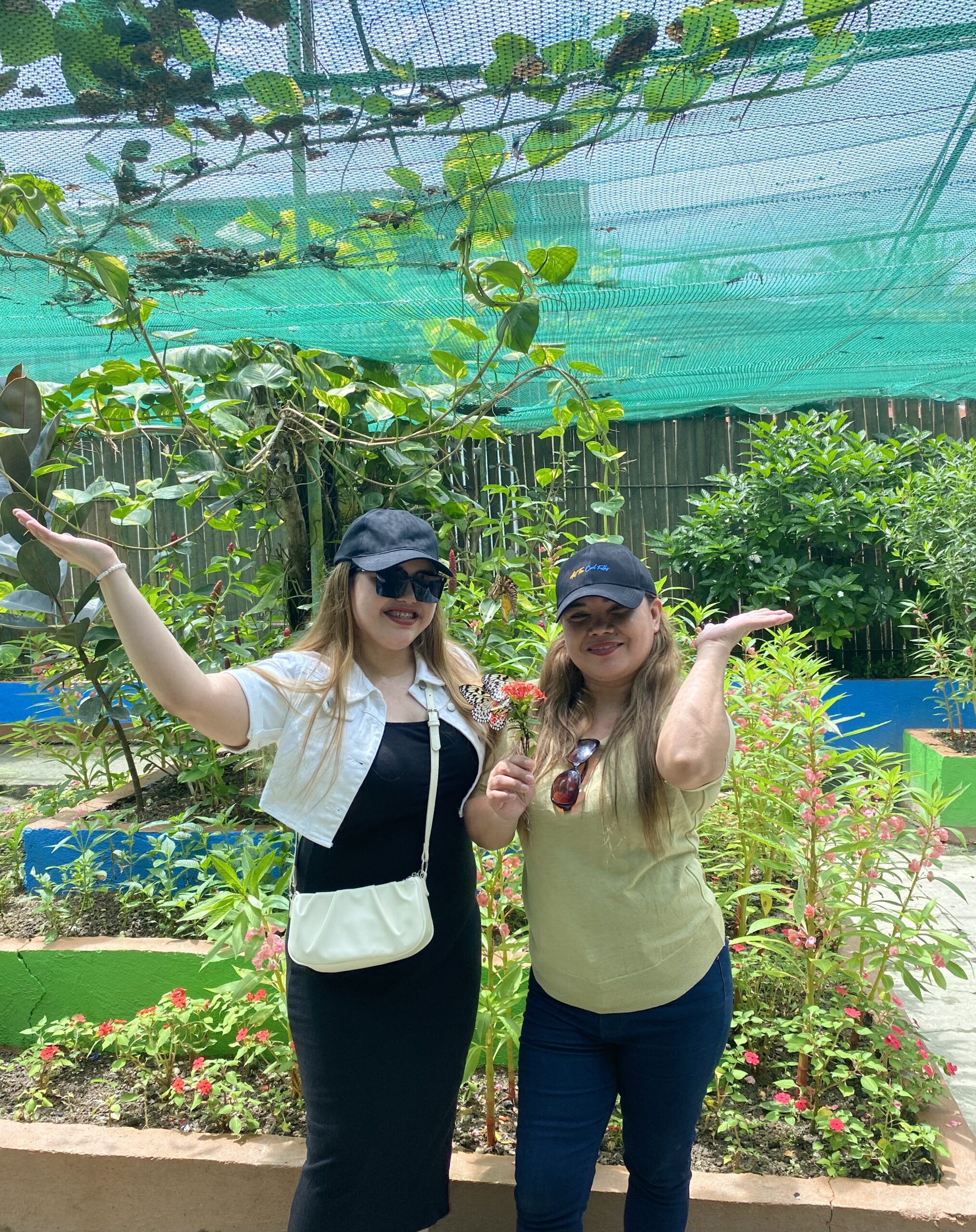 Two women standing together outdoors in a garden